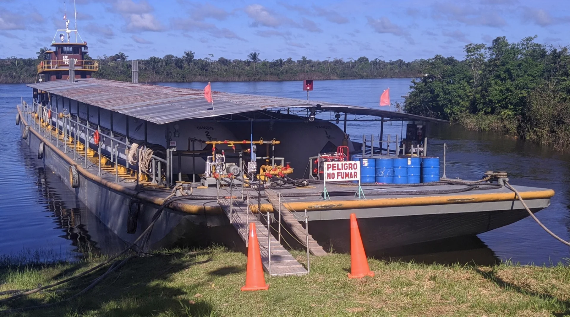Barcaza con dos tanques de GLP a granel navegando junto a la orilla del río